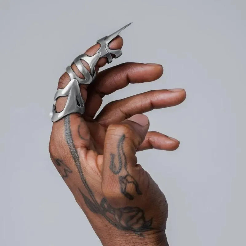Silver punk armour finger stall with large geometric cutout on a model's finger.