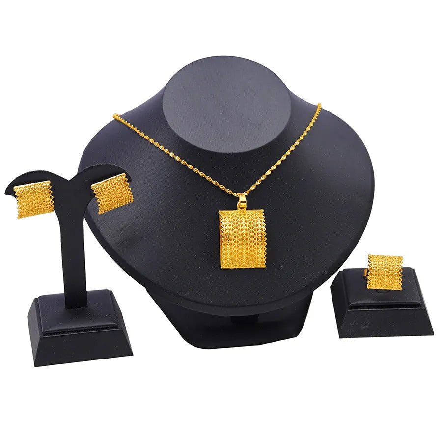 Gold-coloured bridal jewellery set with necklace, earrings, and ring on copper base
