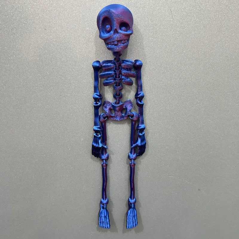 3D printed white Halloween skull refrigerator magnet ornament on a metallic surface.