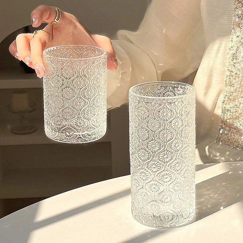 Clear glass water cup with carved Begonia flower pattern, shown in short and tall sizes.