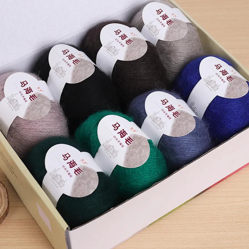 A ball of mohair thread in a chosen colour next to a hand-woven textured scarf sample.