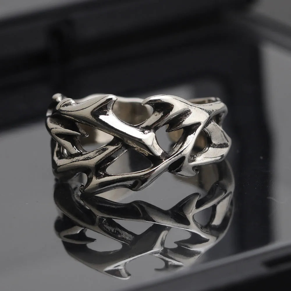 Copper men's ring with thorn and flower design on a geometric band, showing adjustable opening.