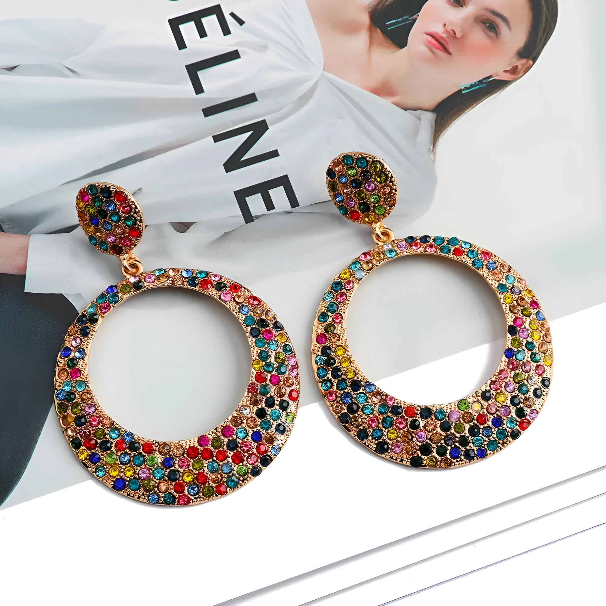 A pair of large round cartoon pendant earrings made from metal alloy, shown in a colour finish.
