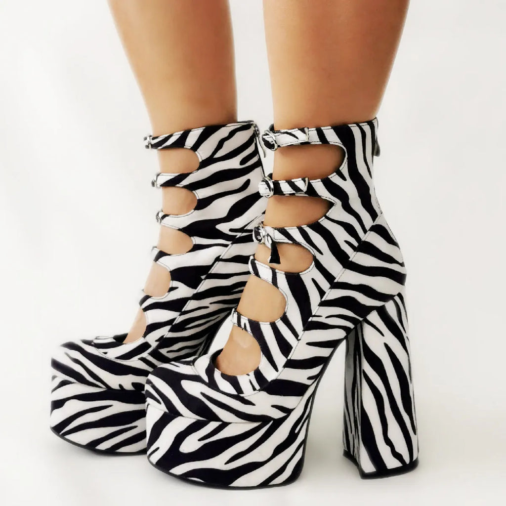 Women's black patent leather platform high heels with a thick heel and serpentine belt buckle.