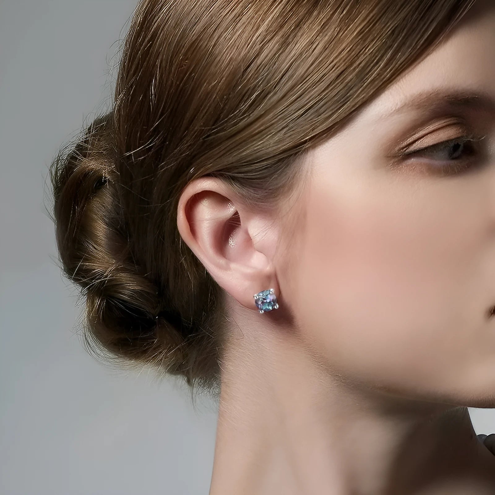 A pair of silver geometric ear studs with a round, coloured Alexander stone setting.