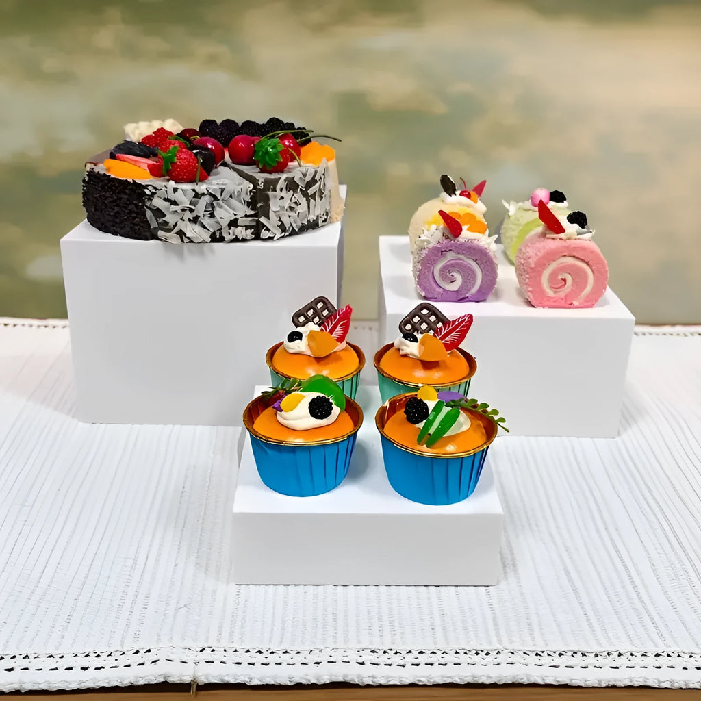 Set of six white plastic dessert display stands arranged on a tabletop.