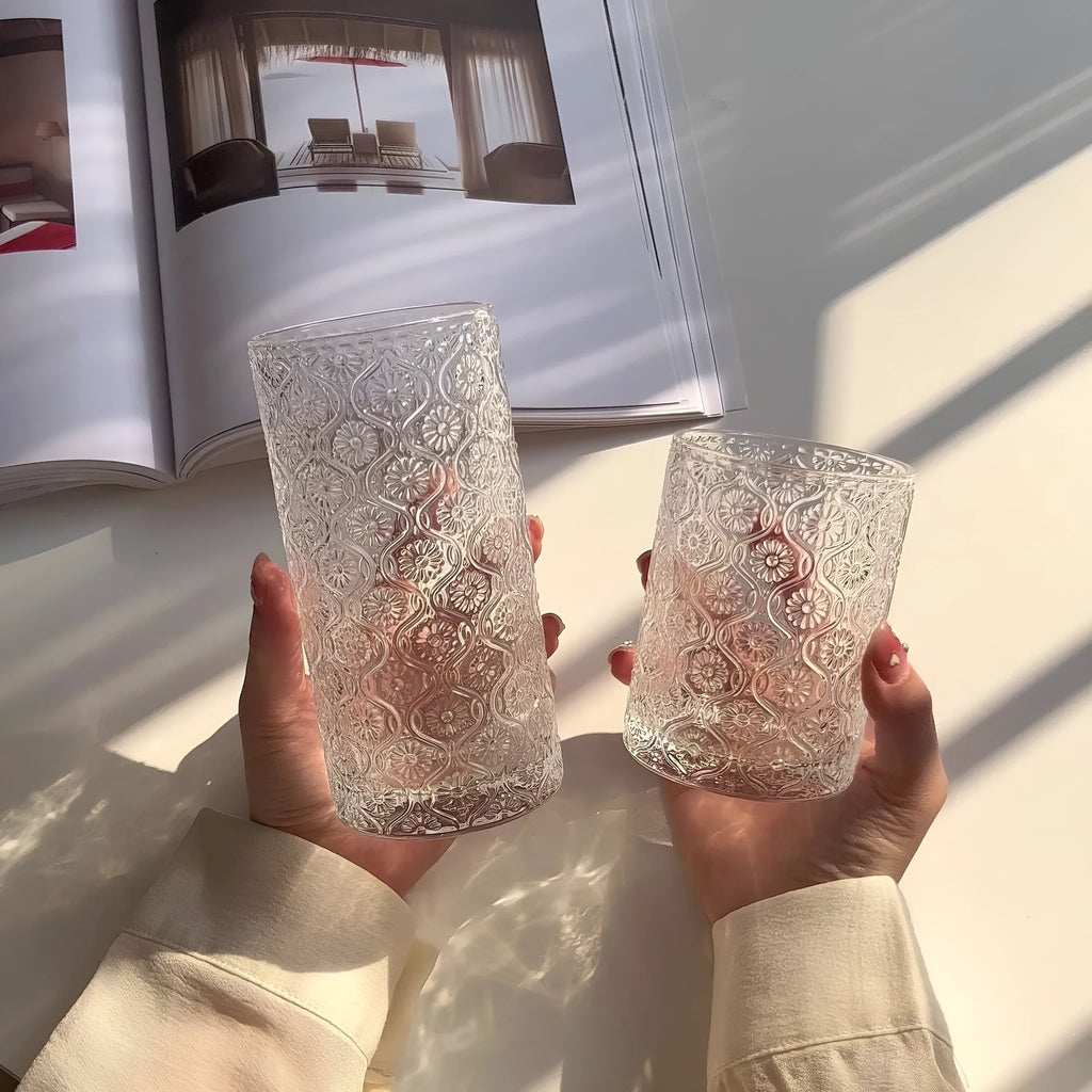Clear glass water cup with carved Begonia flower pattern, shown in short and tall sizes.