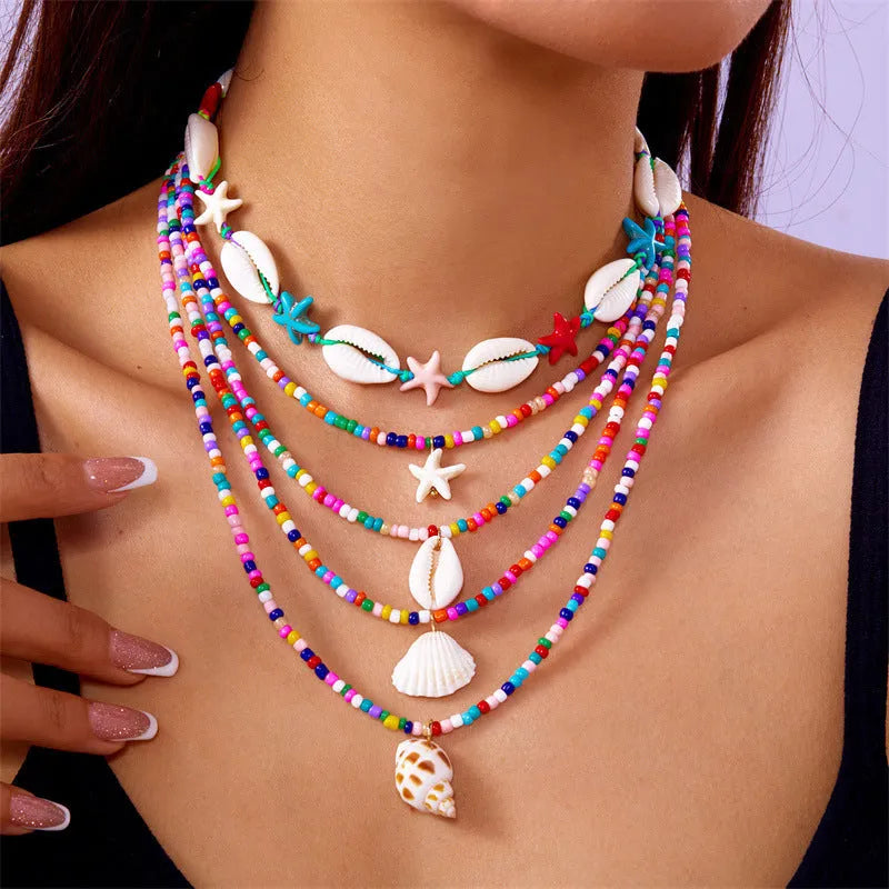 Blue electroplated women's necklace set with starfish and conch shell beads on adjustable chain
