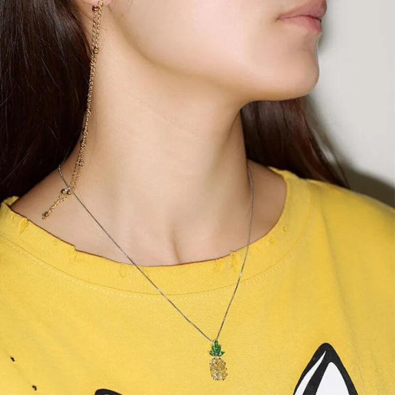 Silver geometric pineapple pendant necklace with a diamond accent on a model