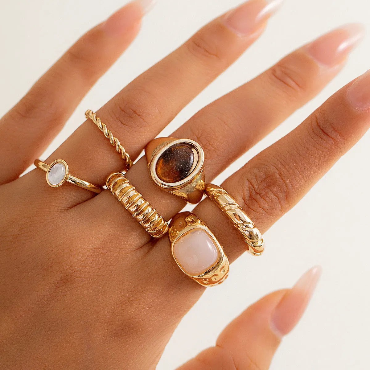 Six light gold electroplated alloy rings in a geometric set with round and ring shapes, style 94509