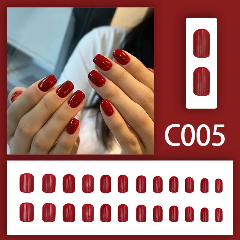 Short solid colour false nails in New Year red with marble pattern, 24 pieces per box with glue for ladies.