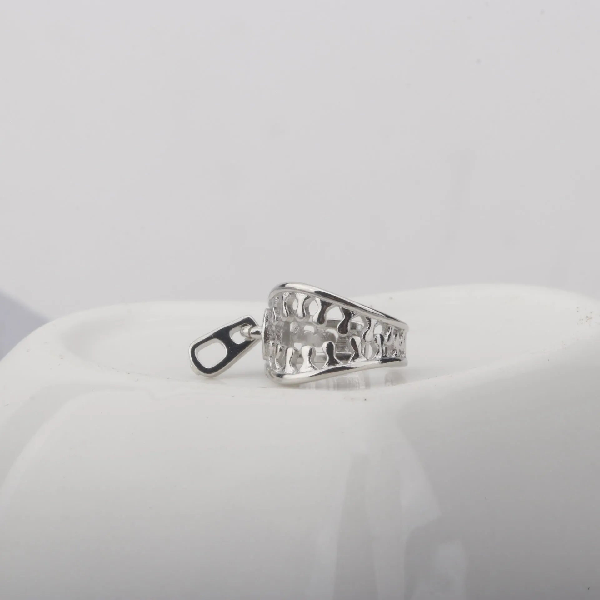 Copper geometric ear clip with line details and a zipper-style clip in colour ES862