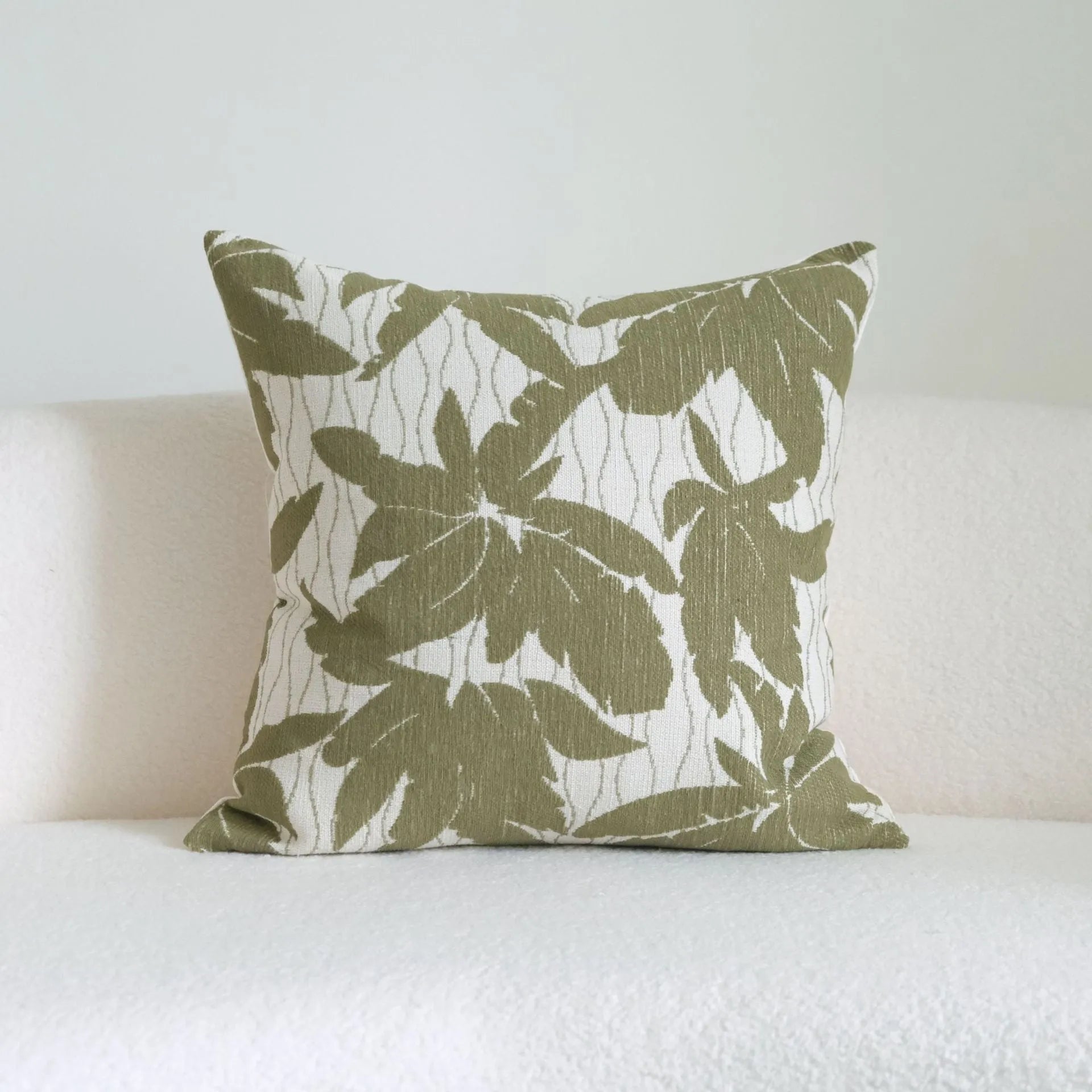 Green striped cotton linen decorative pillow with tassels next to a matching brushed fabric pillow core.