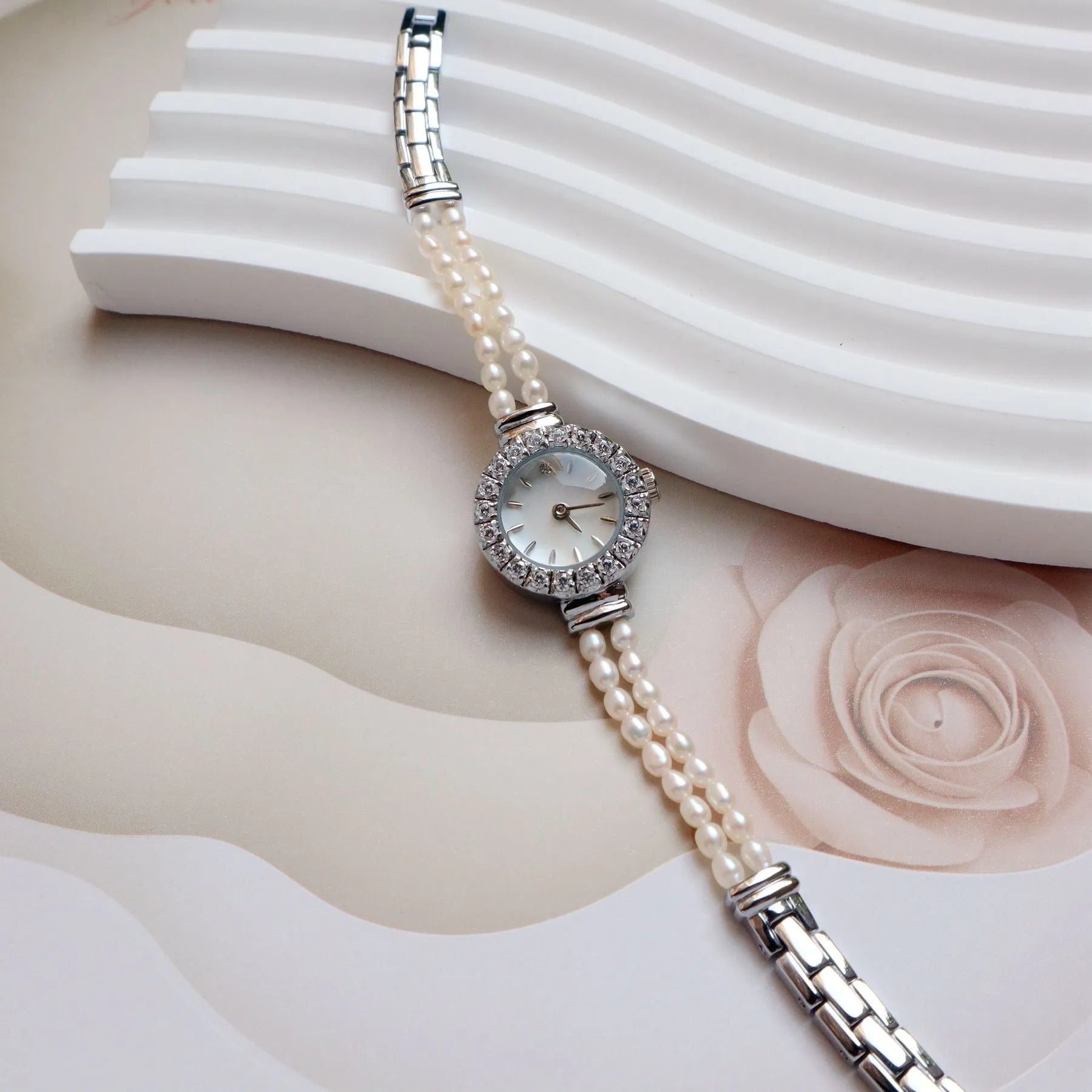 Light gold women's bracelet watch with freshwater pearls and a round 18mm dial.