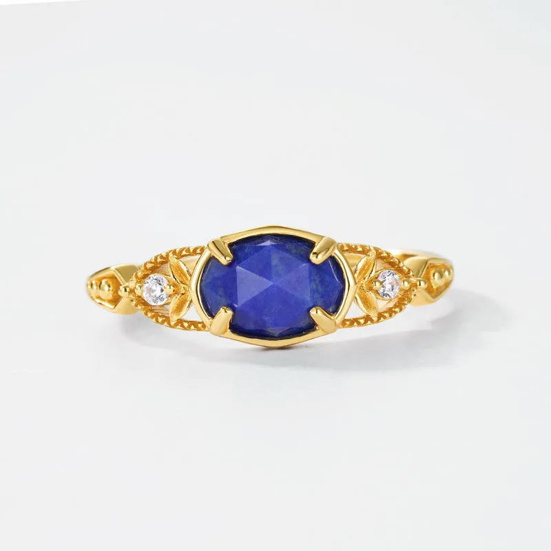 A geometric silver-tone alloy ring in a lapis lazuli colour, showing its elliptical profile and rounded elements.