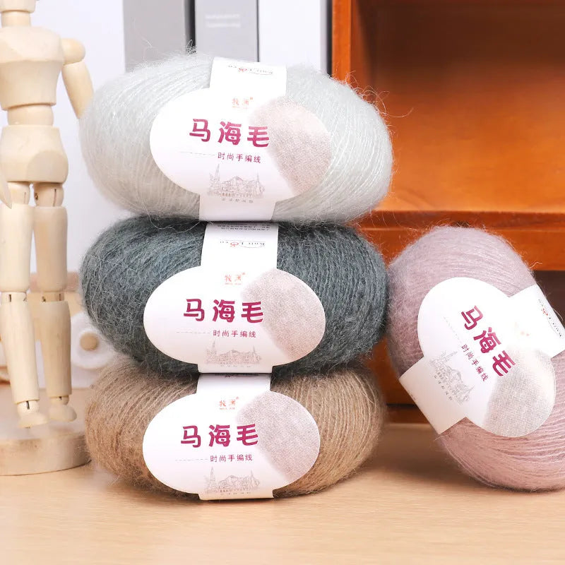 A ball of mohair thread in a chosen colour next to a hand-woven textured scarf sample.
