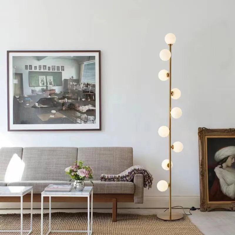 Modern black floor lamp with a glass shade on a wrought iron stand and circular marble base.