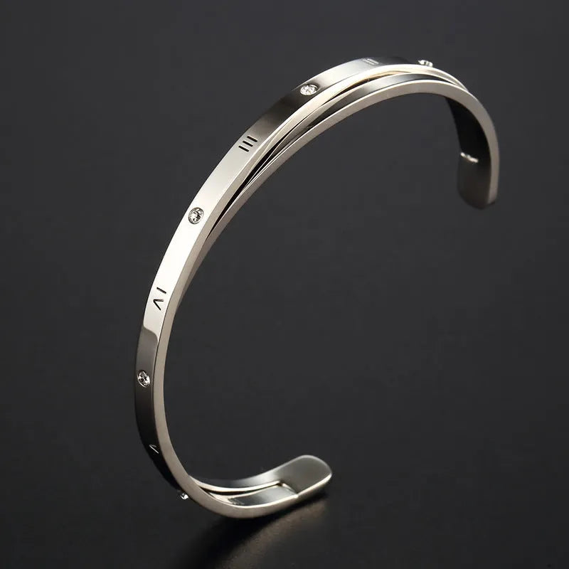 Open-ended stainless steel bracelet with inlaid zircon stones in a love-themed design, shown in rose gold colour.