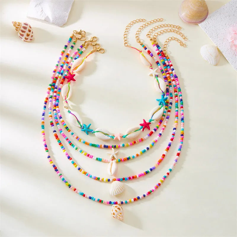 Blue electroplated women's necklace set with starfish and conch shell beads on adjustable chain
