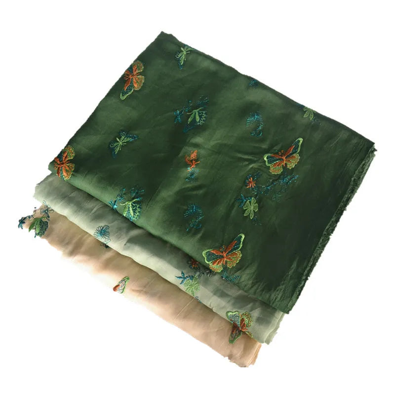Pure ramie embroidery cloth fabric on a roll showing beige, dark green, and grass green colour options.