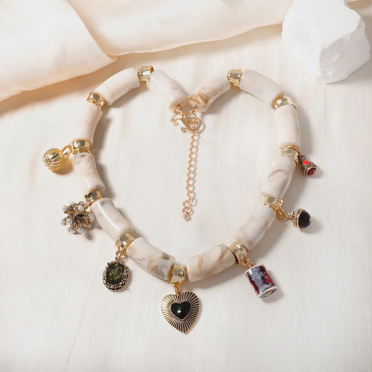 Women's bamboo design heart-shaped resin pendant necklace with electroplated finish.