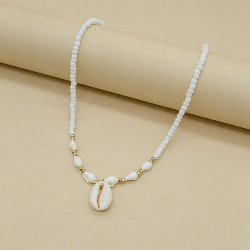 White electroplated shell necklace with conch bead mother-of-pearl pendant on a regular chain.