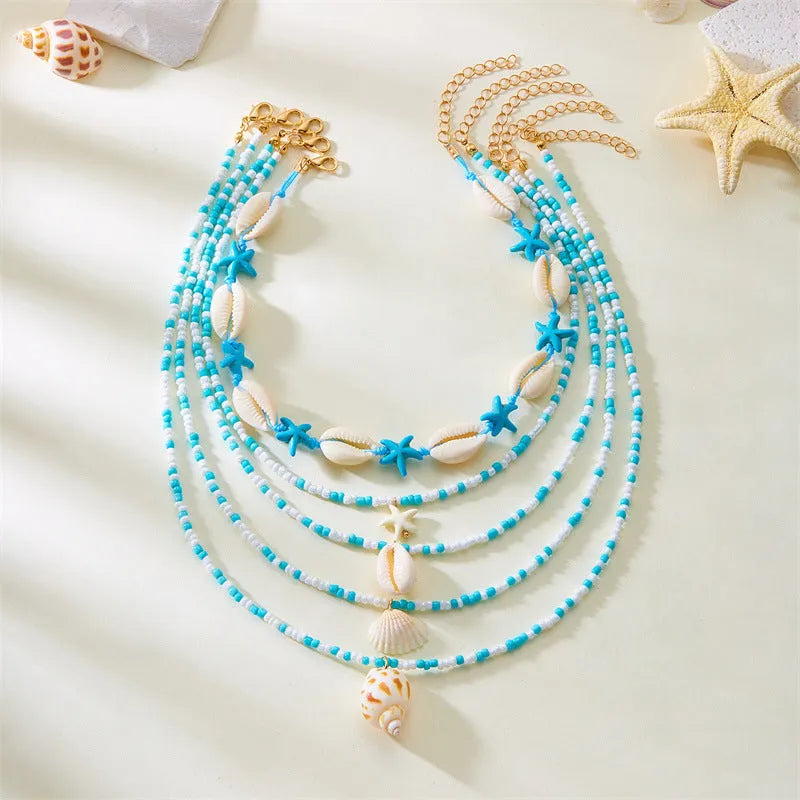 Blue electroplated women's necklace set with starfish and conch shell beads on adjustable chain
