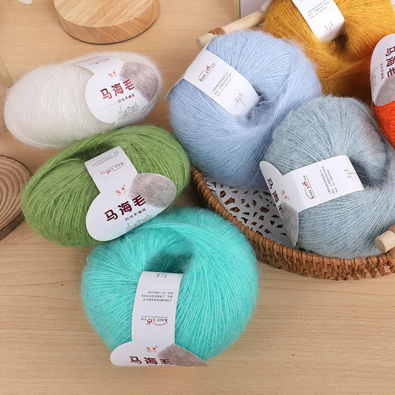 A ball of mohair thread in a chosen colour next to a hand-woven textured scarf sample.