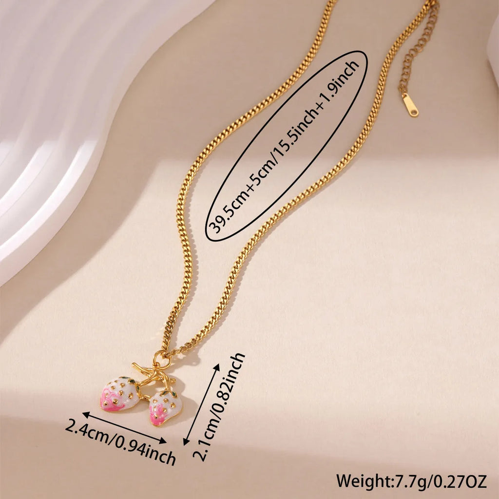 Close-up of a strawberry-shaped alloy pendant necklace on a stainless steel chain, showing red and white colour options.
