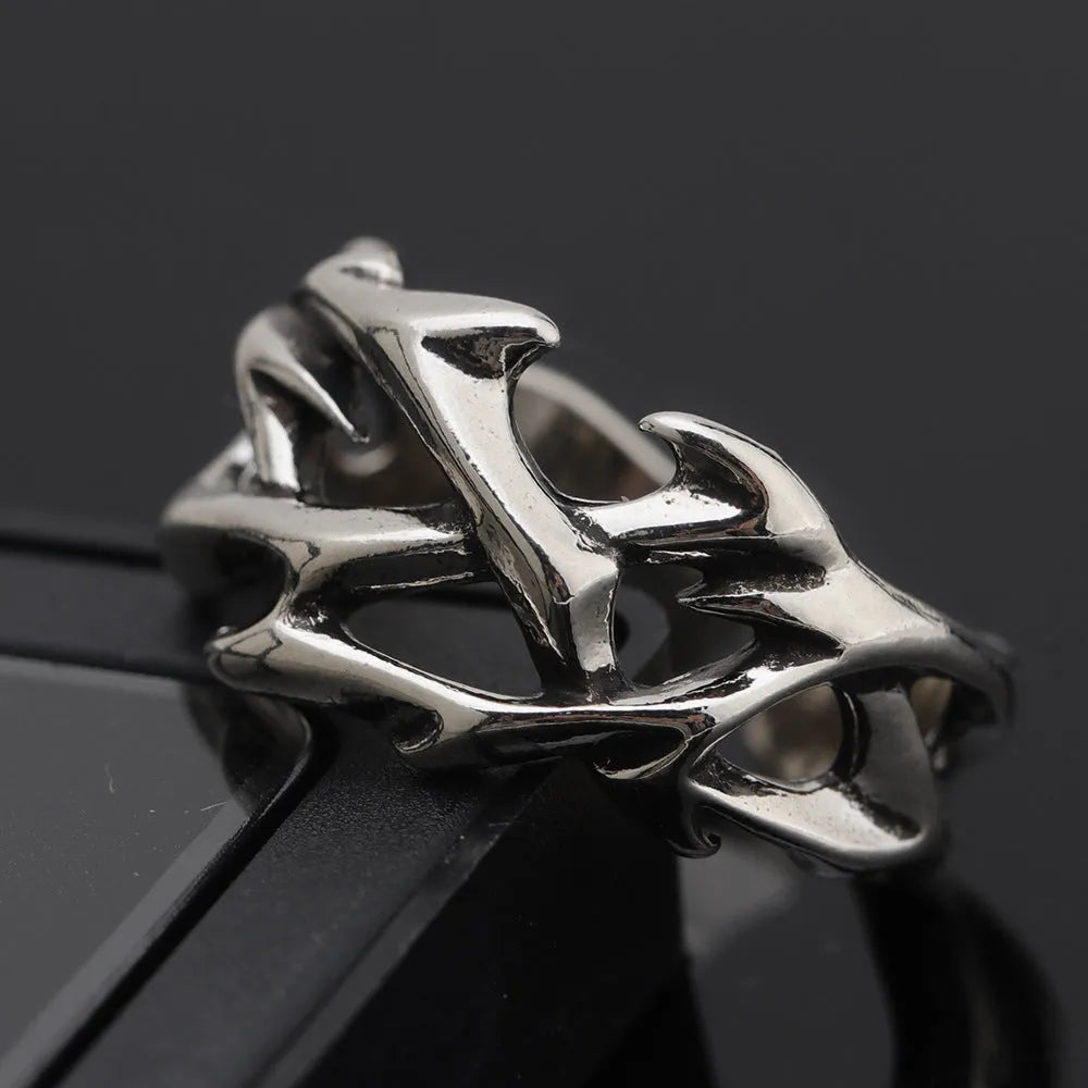 Copper men's ring with thorn and flower design on a geometric band, showing adjustable opening.