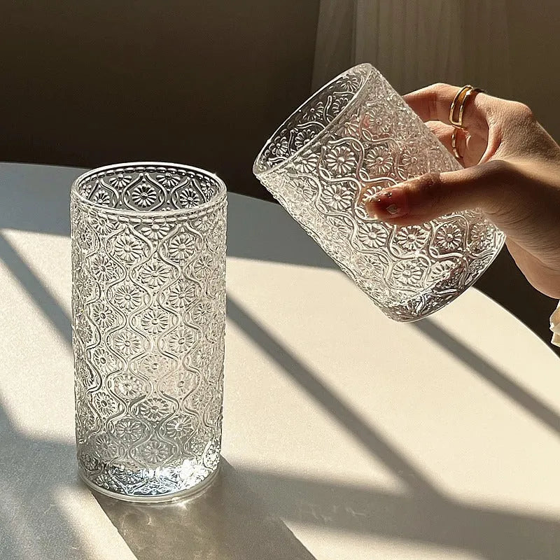 Clear glass water cup with carved Begonia flower pattern, shown in short and tall sizes.
