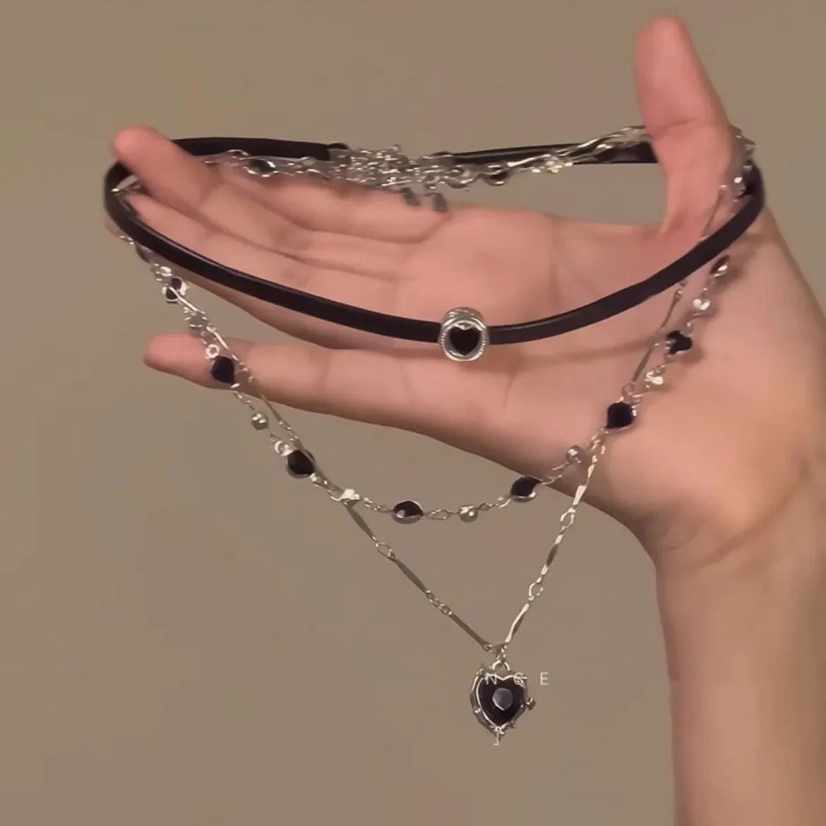 Women's leather and alloy double-layer heart pendant necklace on an adjustable clavicle chain.