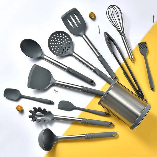 Black silicone kitchen utensil set with 12 tools in a rotating storage bucket on a kitchen countertop