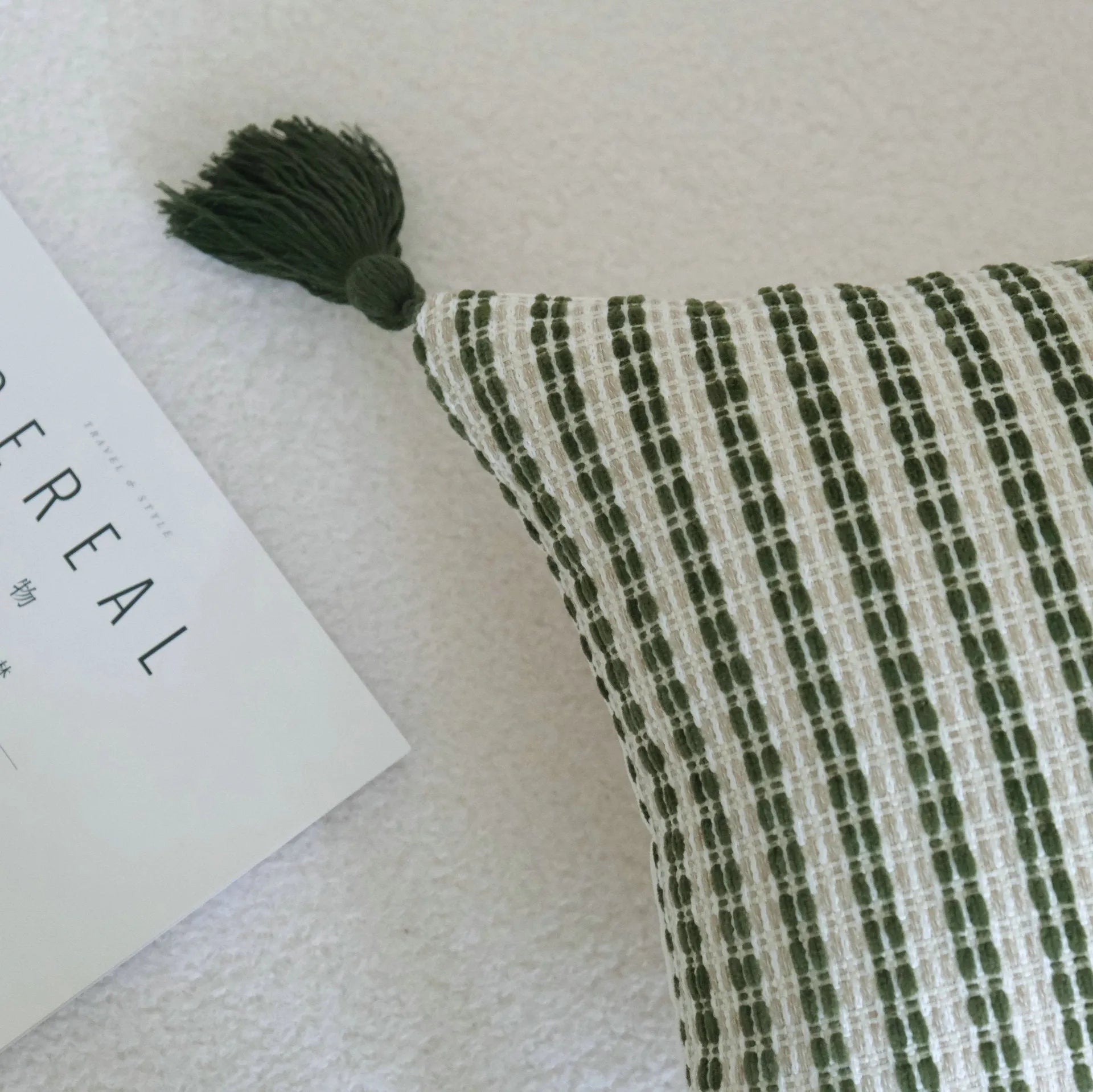 Green striped cotton linen decorative pillow with tassels next to a matching brushed fabric pillow core.