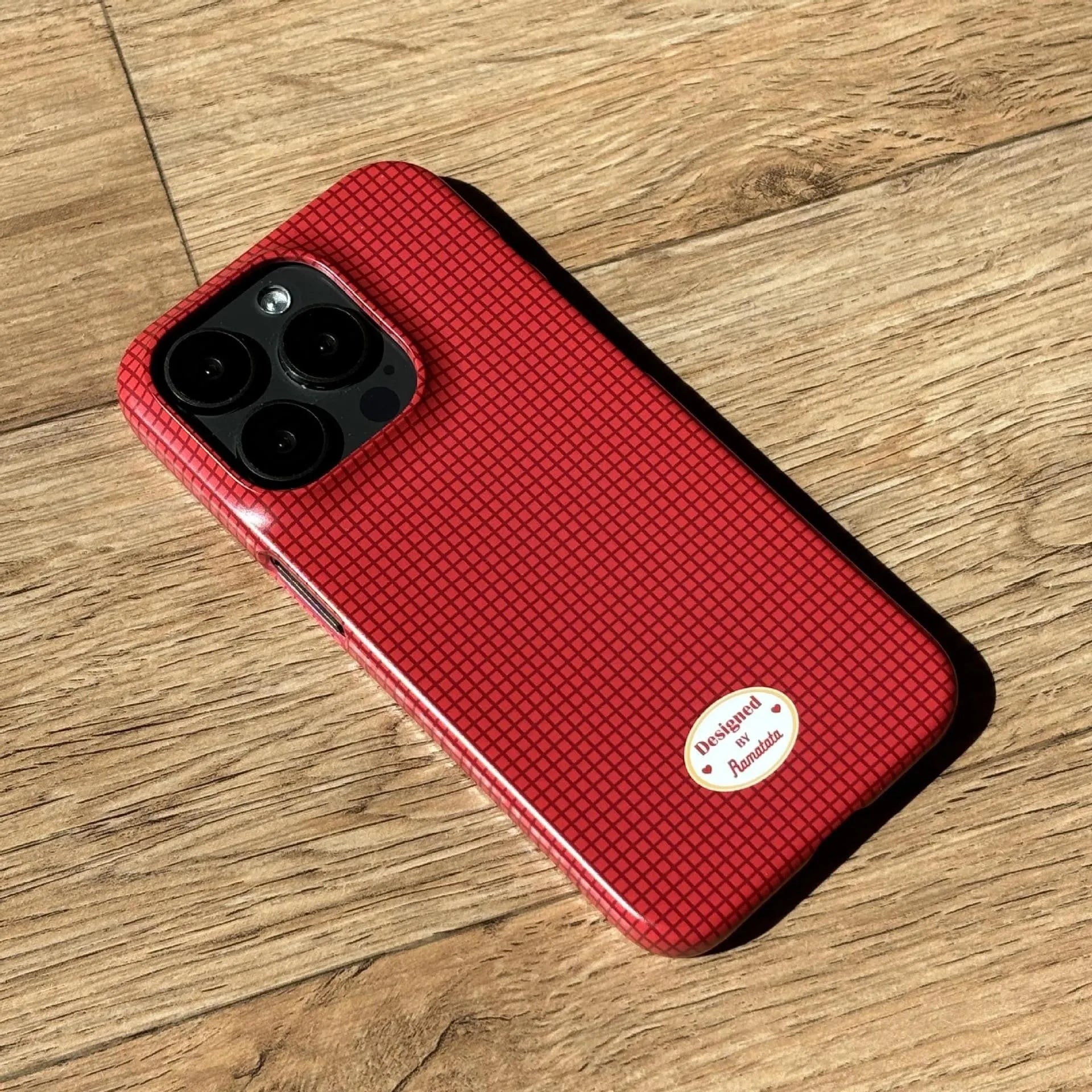 Red and orange plaid iPhone 15 Pro Max phone case with glossy and frosted finish options.