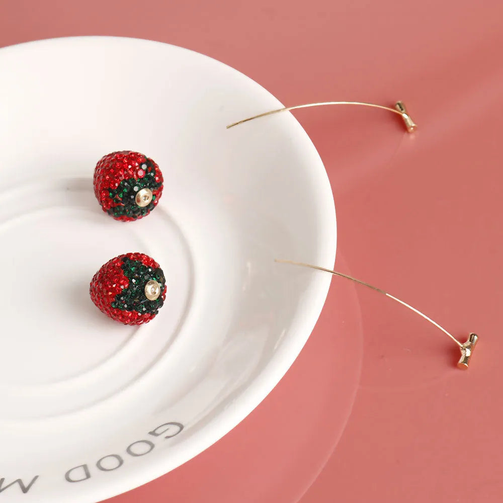 Geometric strawberry-shaped zinc alloy earrings with spot-drill texture, shown in red, on a white background.