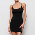 A black skinny sheath dress with a sling neckline and short mini length on a model.