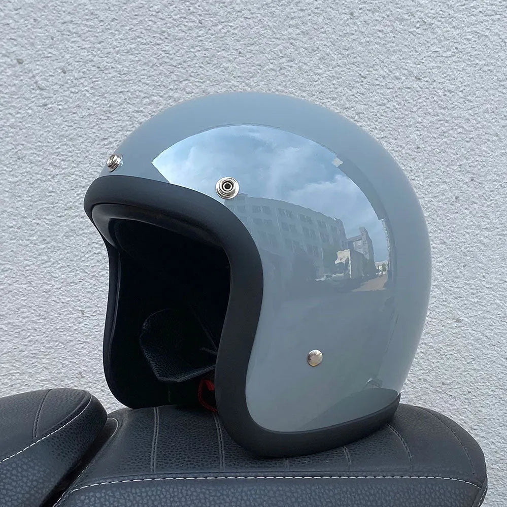 Retro-style open-face motorcycle half helmet in cement grey with a glossy FRP shell and quick-release chin strap.