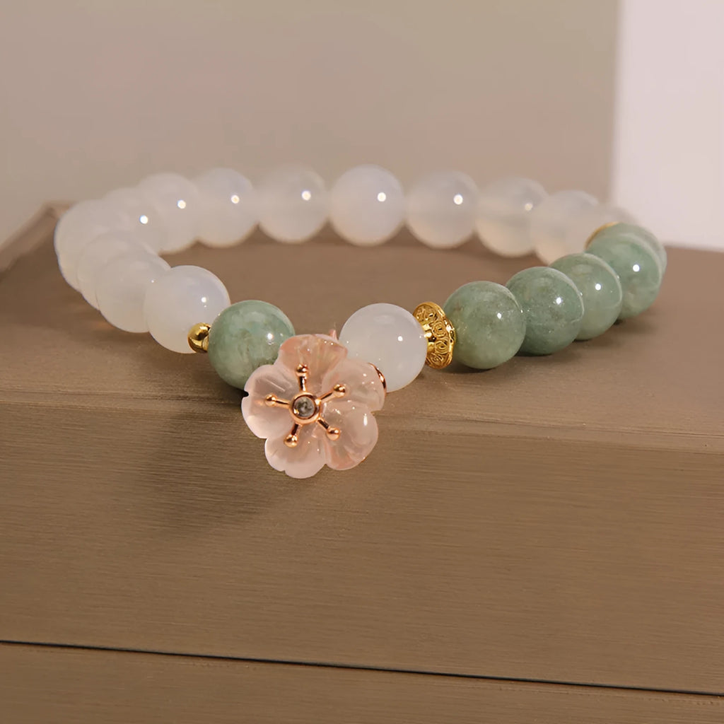 White agate jade bracelet with floral shape on a casual model wrist.