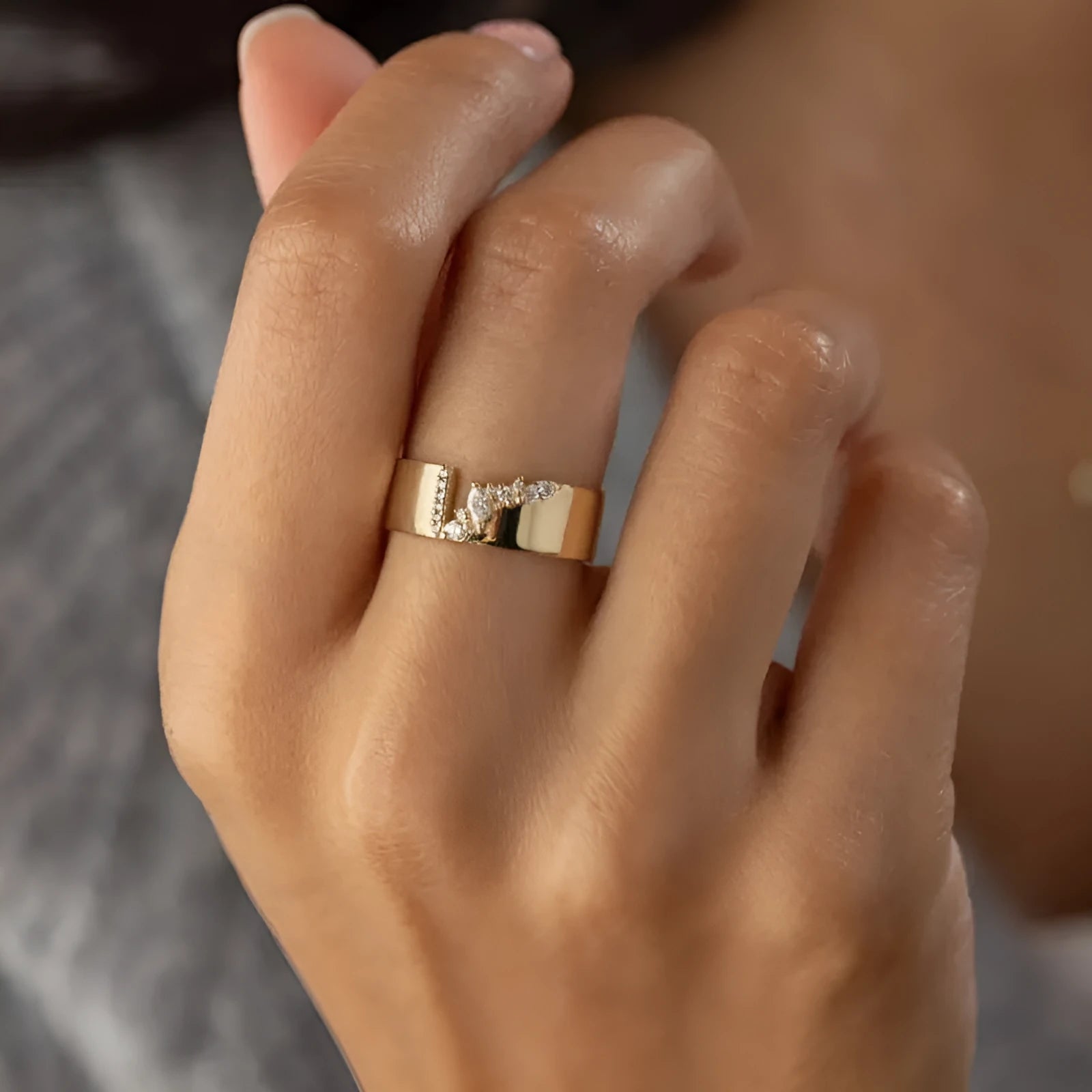 Gold electroplated copper ring for women with shining zircon details, shown on a finger.