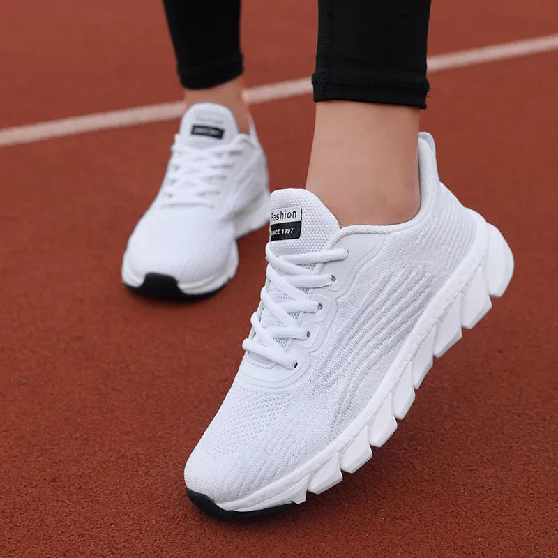 Women's low-top black and white casual running sneakers with MD sole and cross-strap detail.