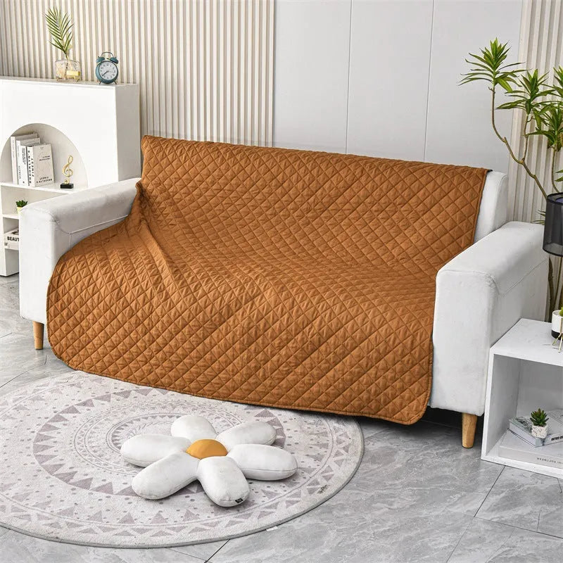Reversible waterproof dog blanket on a sofa showing two colour sides, available in black, burgundy, camel, coffee and grey.
