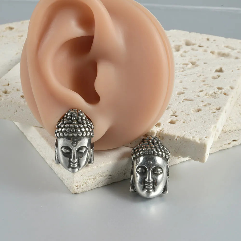 Stainless steel hollow skull earrings next to Buddha head style, showing electroplated gold and black colour options.