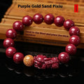 Polished purple and gold sandstone cinnabar bracelet with totem design on a wrist.