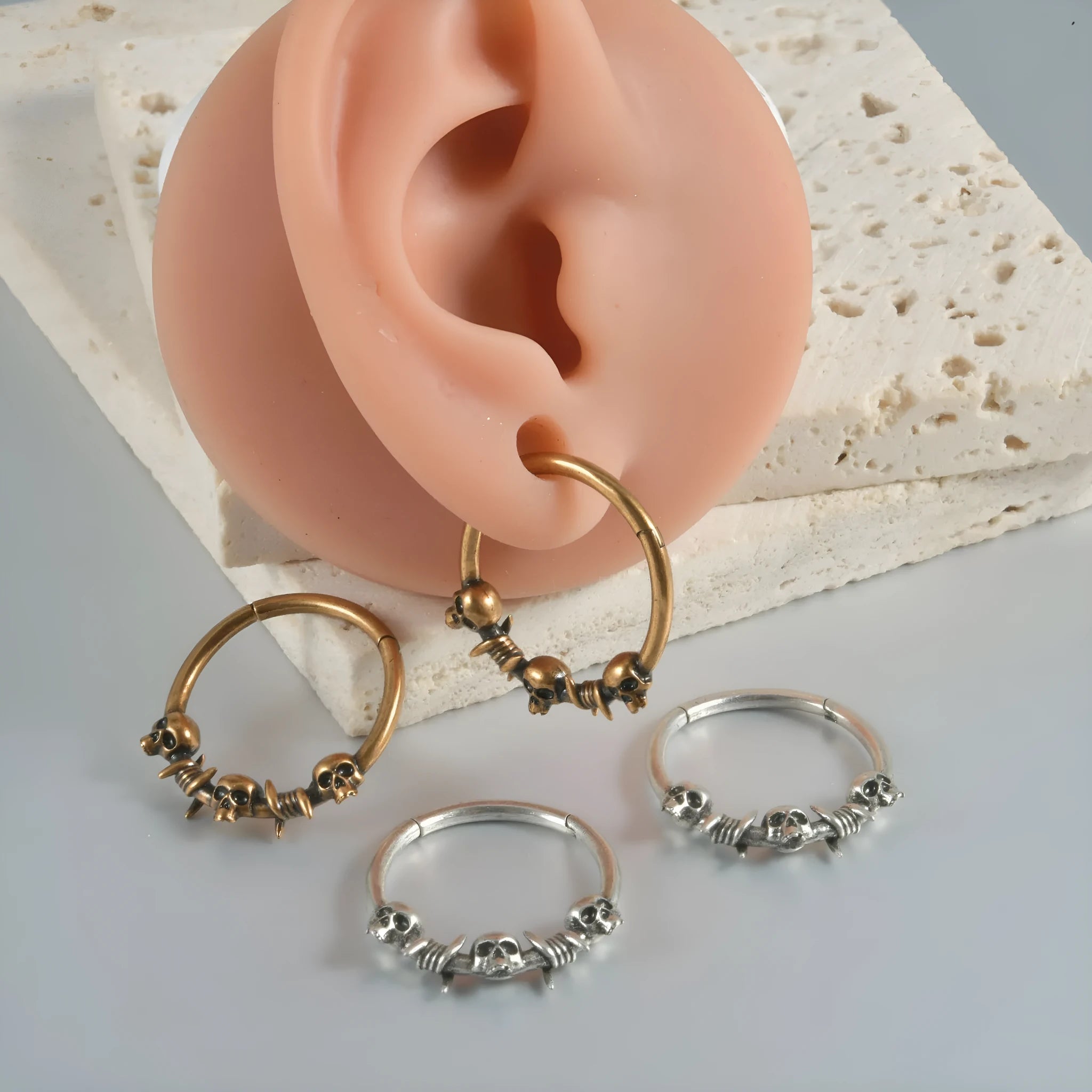 Close-up of vintage-style copper ghost head earrings with antique silver plating on a dark background.