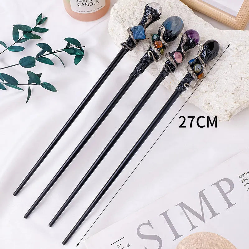 Natural crystal magic wand with labradorite stone ball on simple handle against neutral background