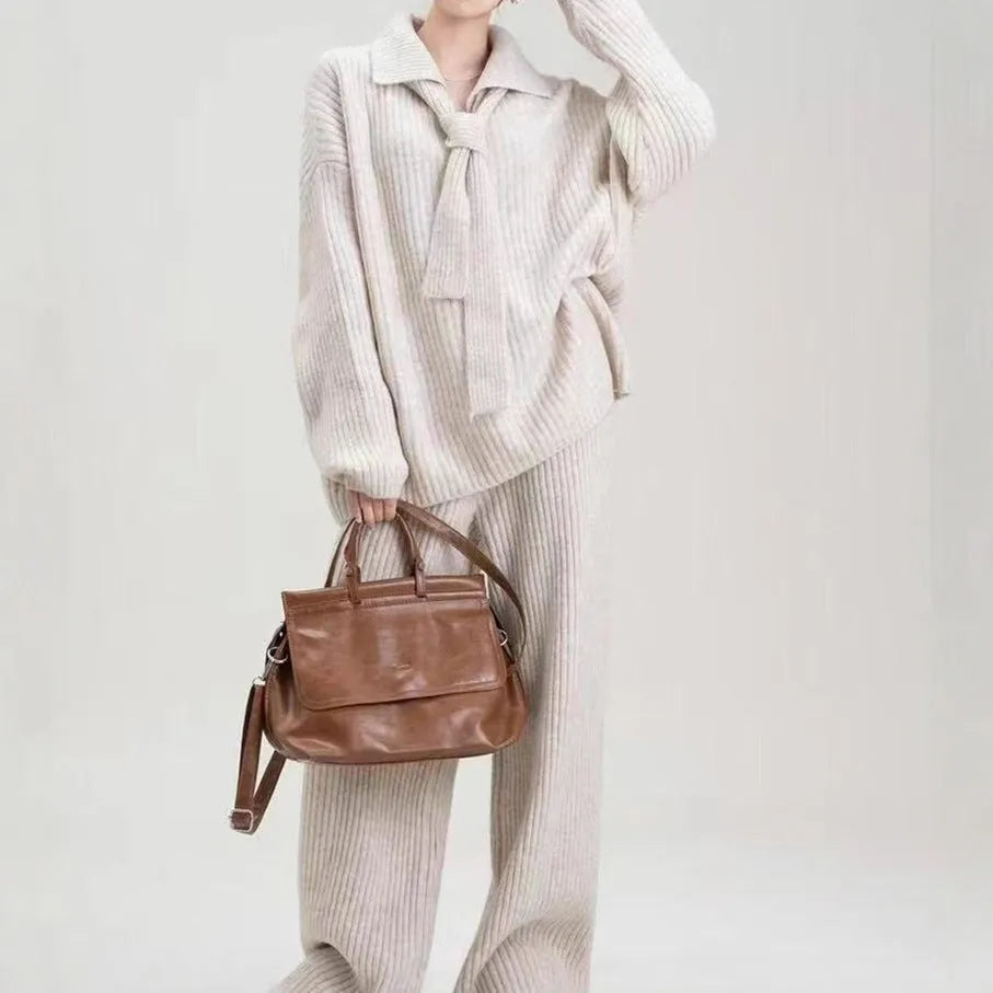 Women's beige knitted top and trousers two-piece set with long sleeves on a hanger.