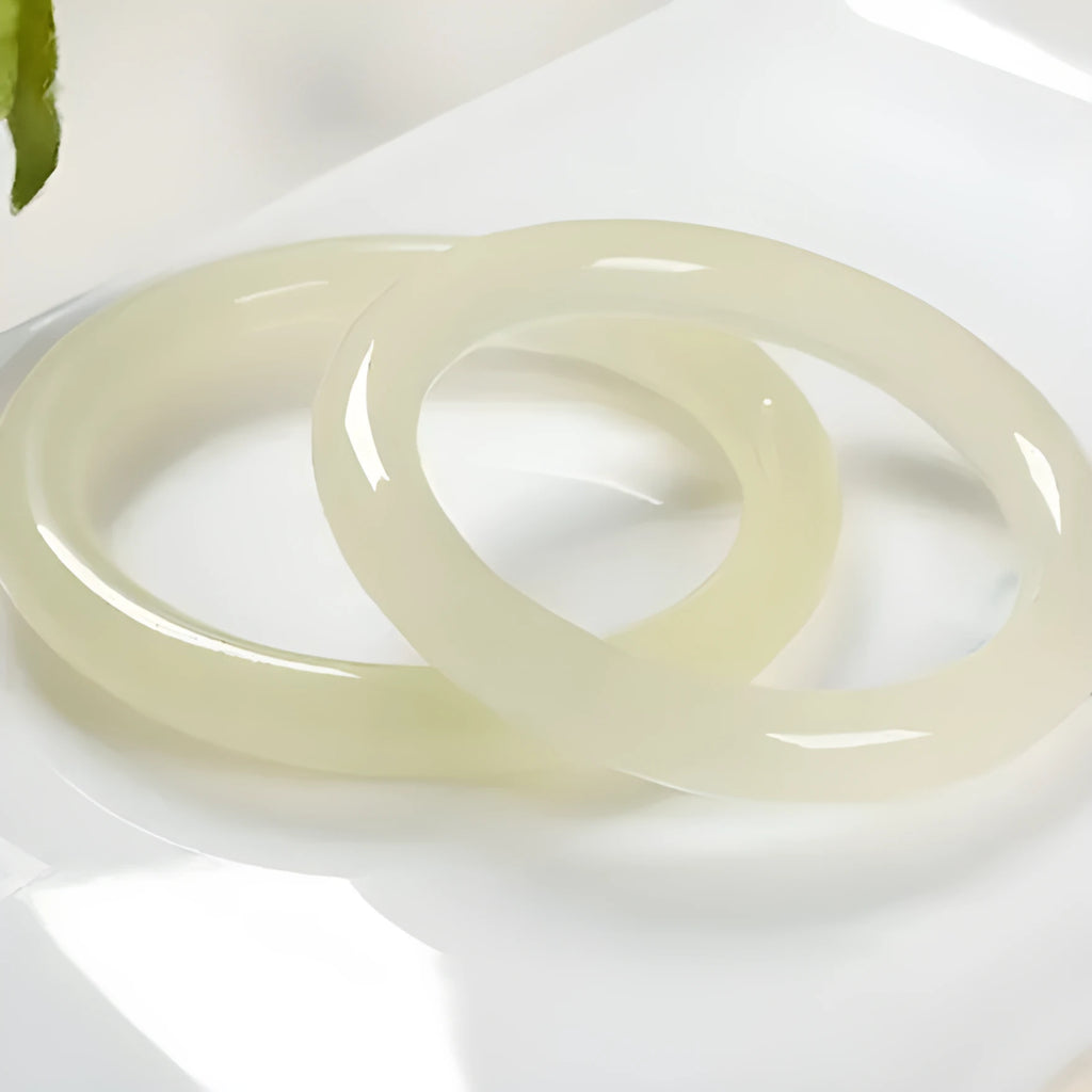 A close-up of a winding jade bracelet made from round bar beads on a wrist.