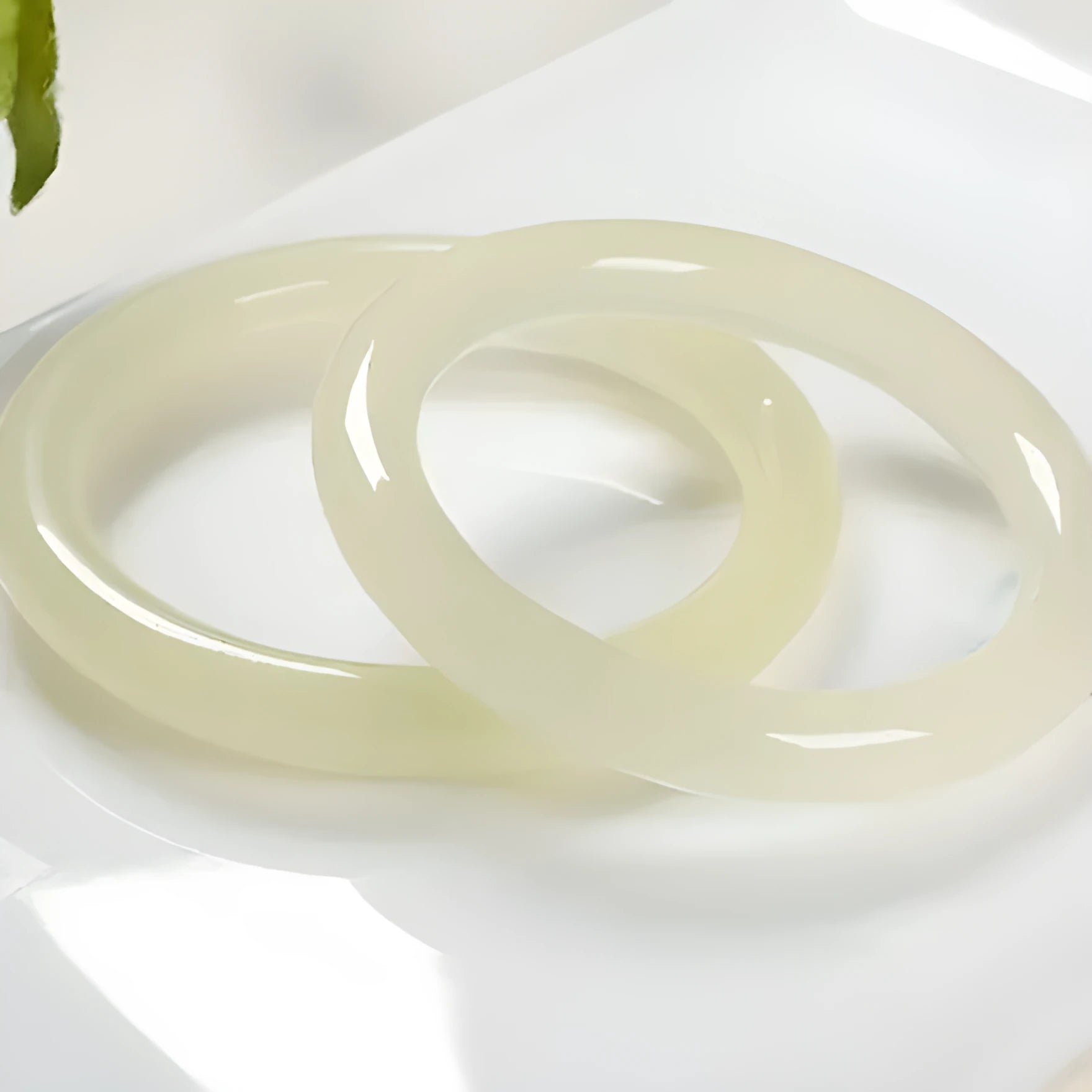 A close-up of a winding jade bracelet made from round bar beads on a wrist.
