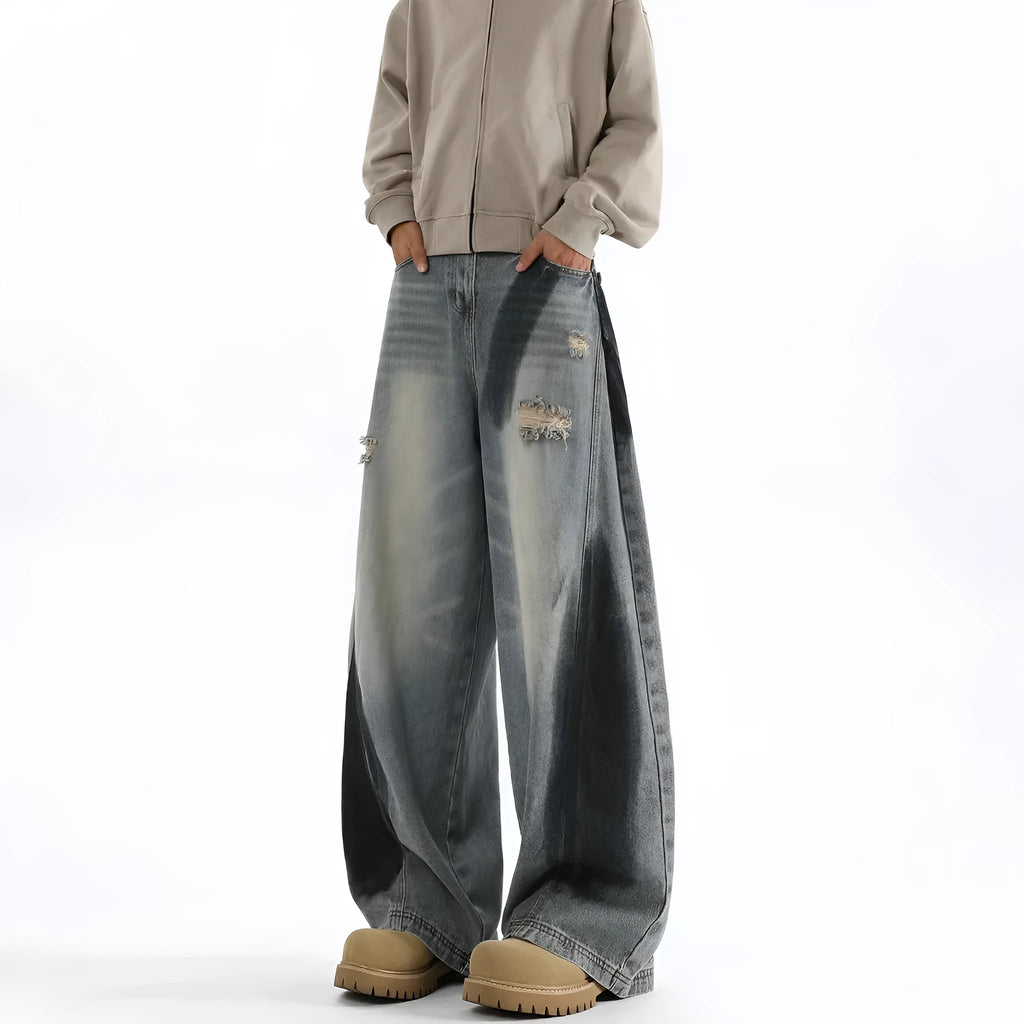 Blue men's loose fit jeans featuring a splash-ink pattern and ripped knee detailing.
